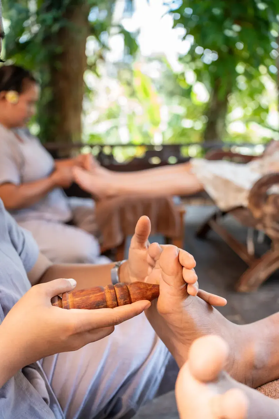 A therapist working on a guest’s foot with a massage tool