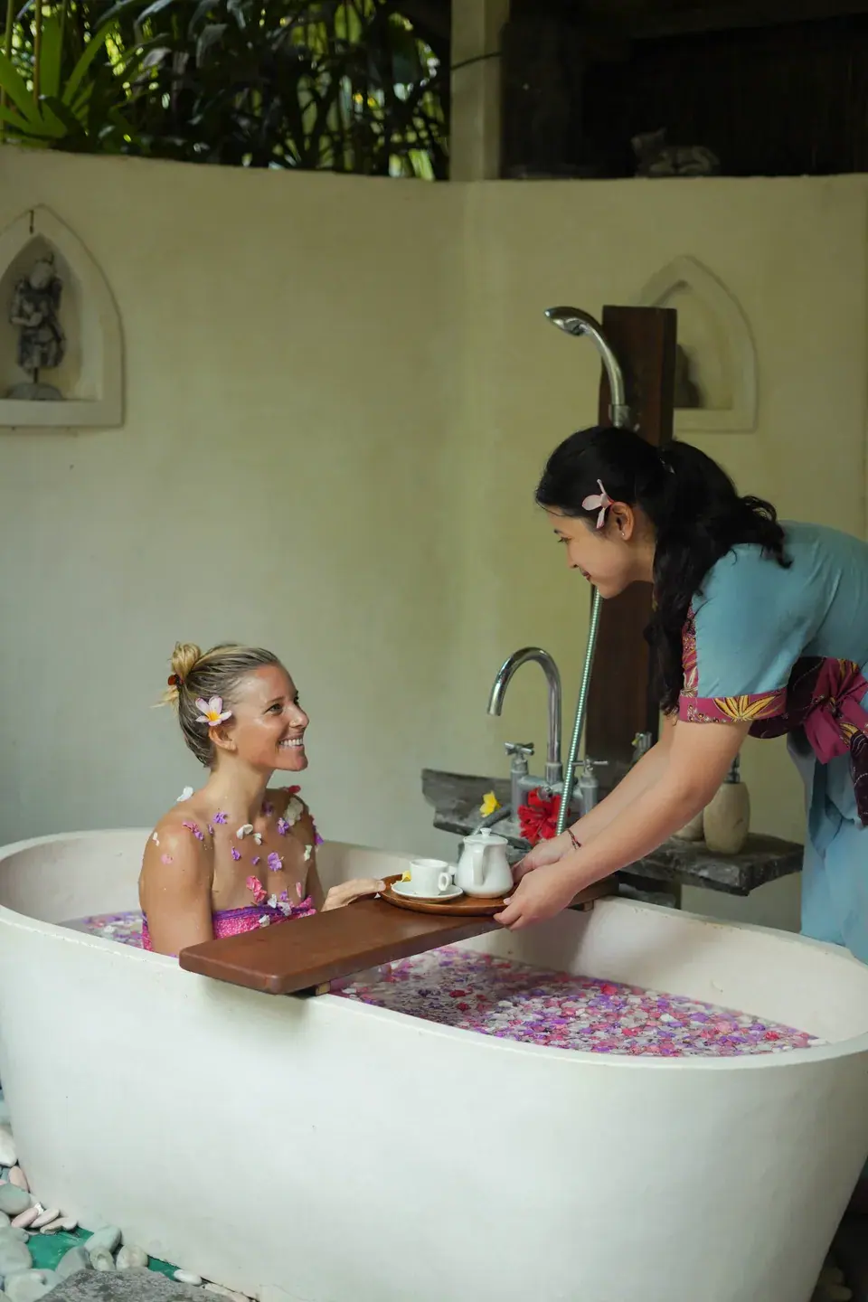 A therapist attending to a guest in a flower bath
