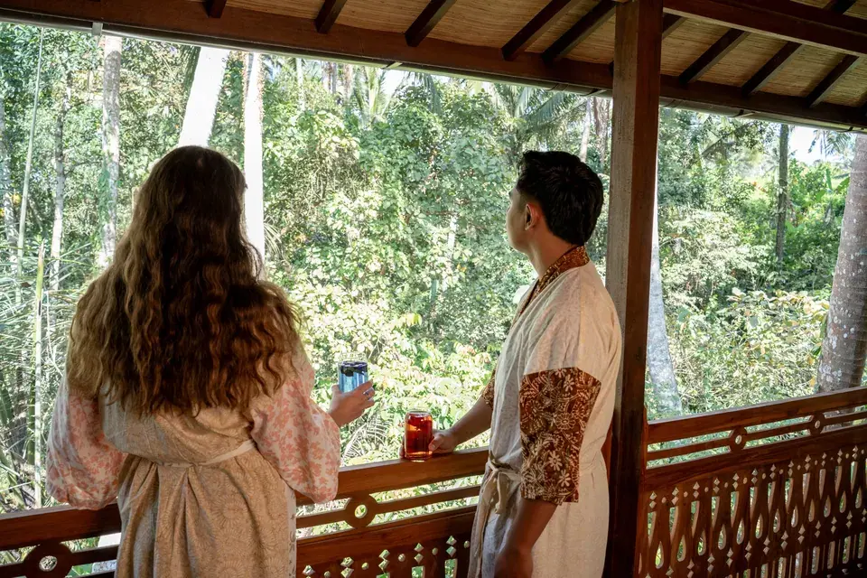 Guests looking out from the wooden verandah towards surrounding trees