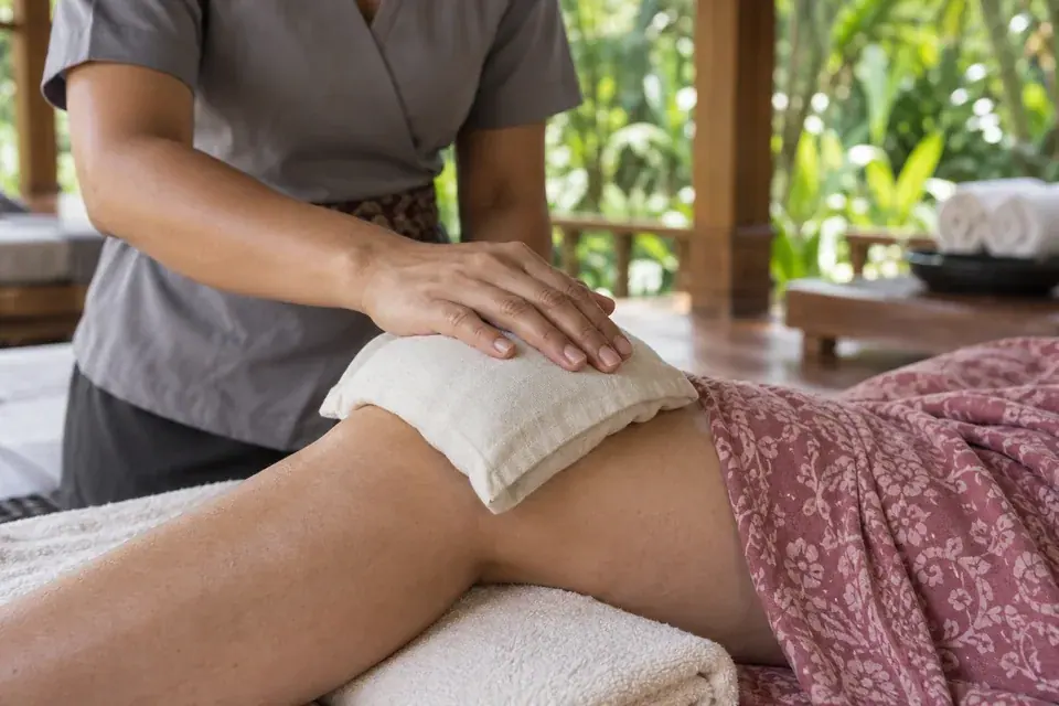A clean cloth herbal compress resting over the knee